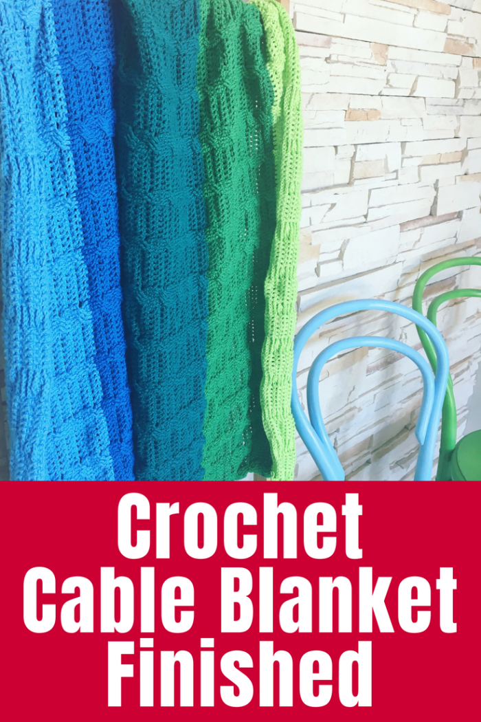My crochet cable blanket is finished and looking lovely in shades of green and blue cotton. Find out all the details and where to find the pattern.
